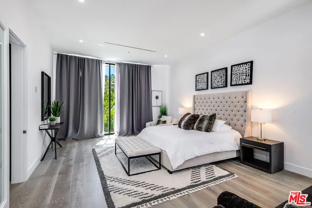 a bedroom with a large bed and a large window