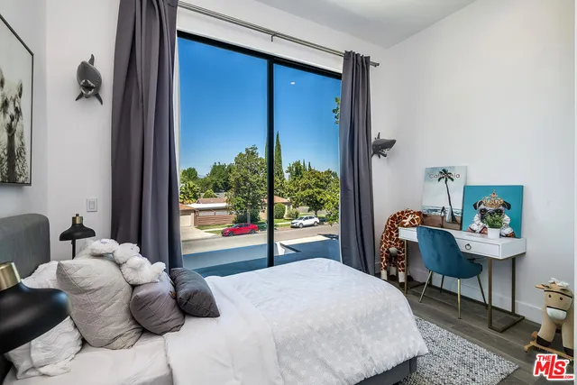 a bedroom with furniture and a large window