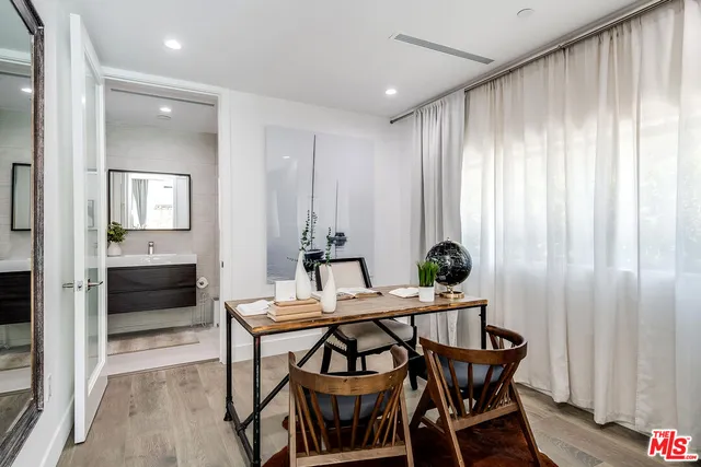 a view of a dining room and kitchen with furniture wooden floor and a chandelier