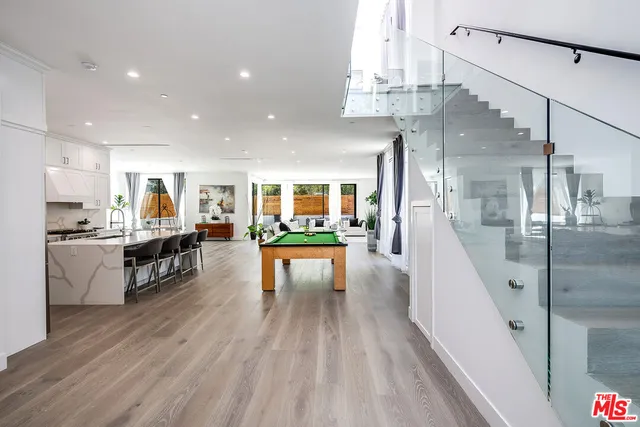 a living room with stainless steel appliances furniture and a kitchen view