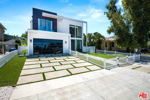 a building exterior with furniture and garden