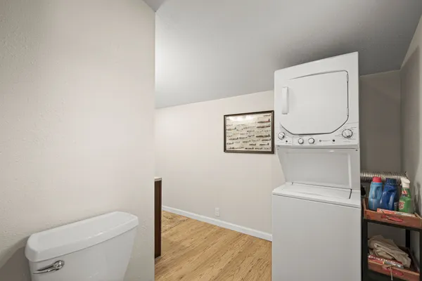 a bathroom with a toilet and a wooden floor