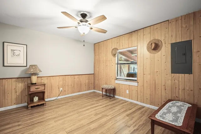 a view of an empty room with window and wooden floor