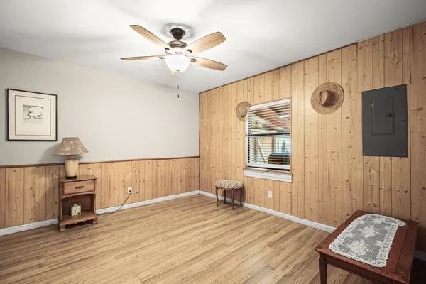 a view of an empty room with window and wooden floor
