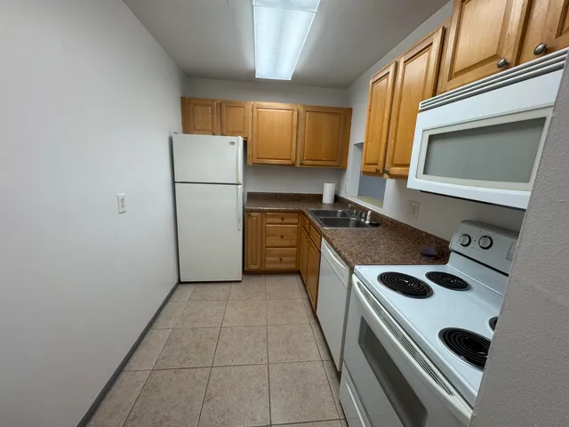 a kitchen with a stove a refrigerator and a sink