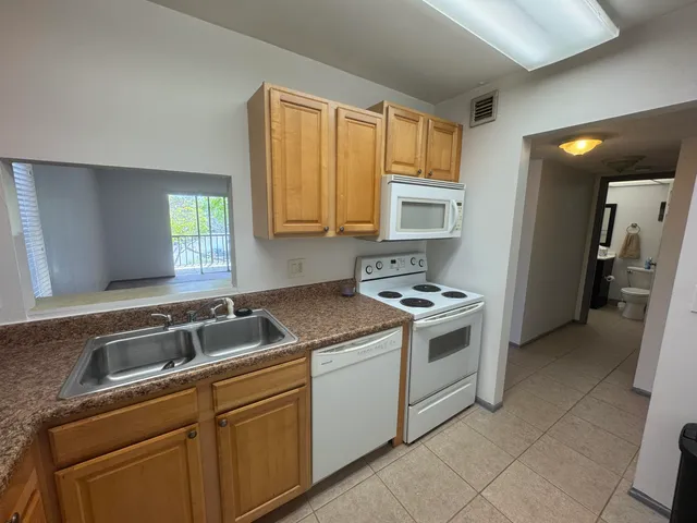 a kitchen with a stove sink and cabinets