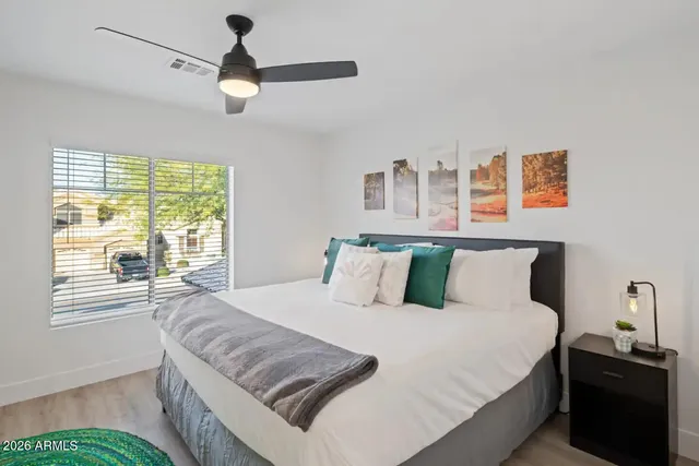 a bedroom with a bed and a large window