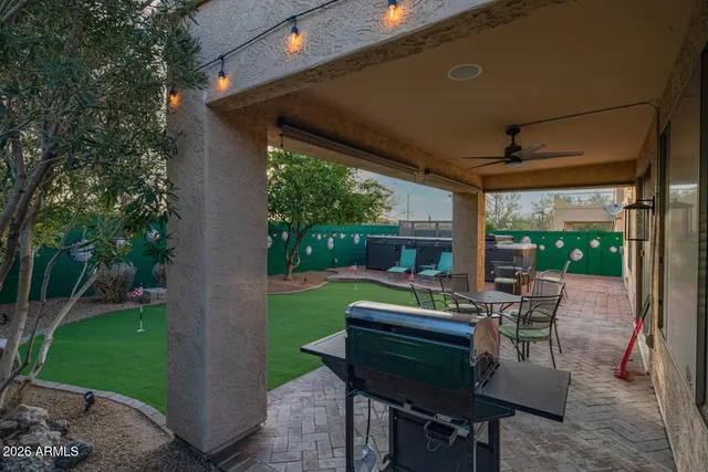a view of a patio with table and chairs potted plants and a large tree