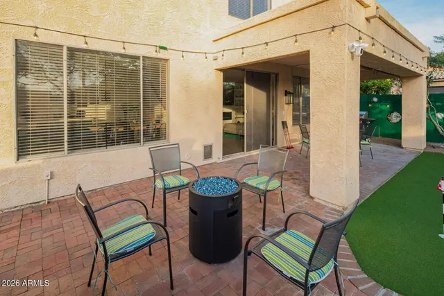 a view of a chairs and table in back yard of the house