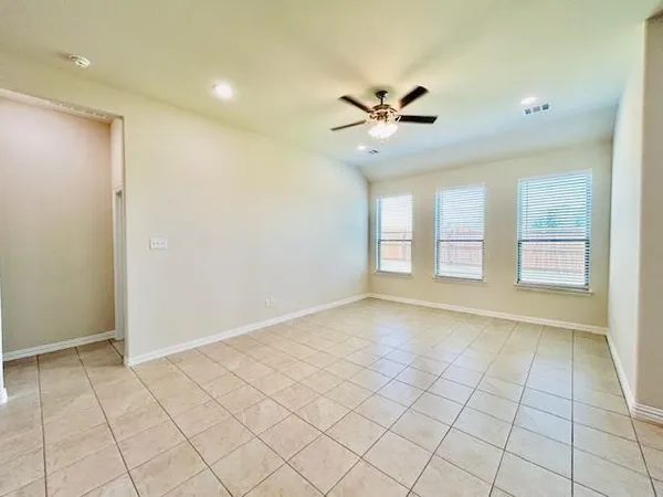 a view of an empty room and window a ceiling fan