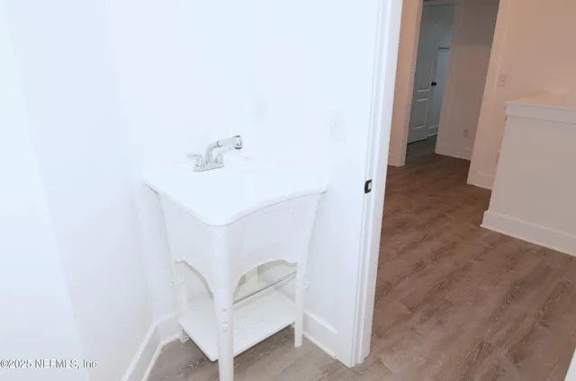 a view of empty room with wooden floor and window