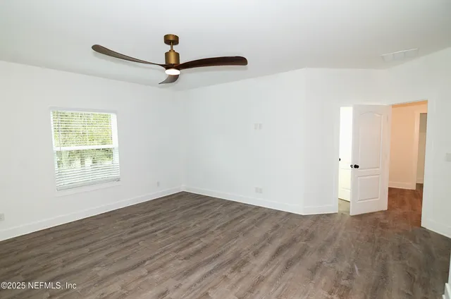 a view of an empty room with wooden floor