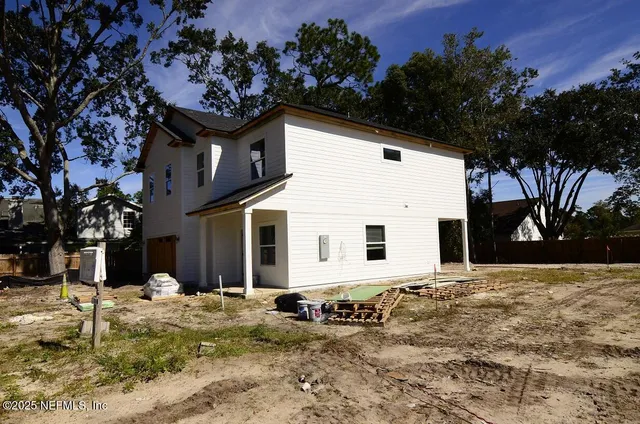a view of a kitchen with kitchen island a sink wooden floor and a refrigerator