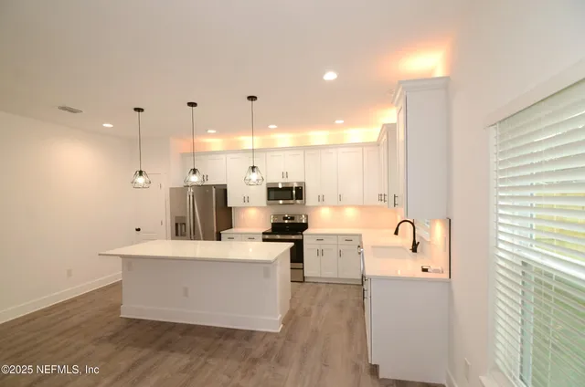 a kitchen with a sink cabinets and window