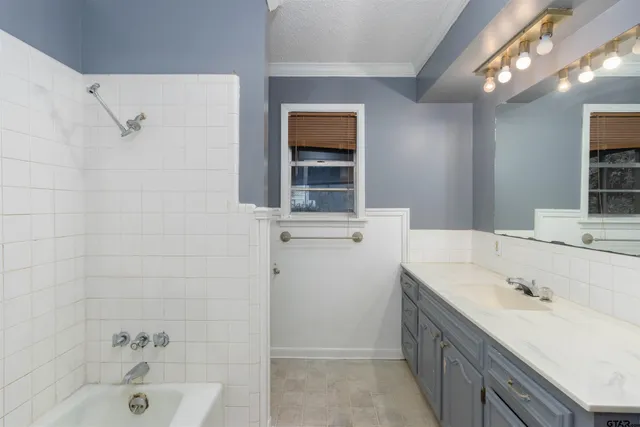 a bathroom with a tub sink and mirror