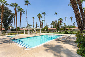 41885 Largo Palm Desert, CA 92211 - Photo 24 of 26 a view of a swimming pool with a bench and palm trees