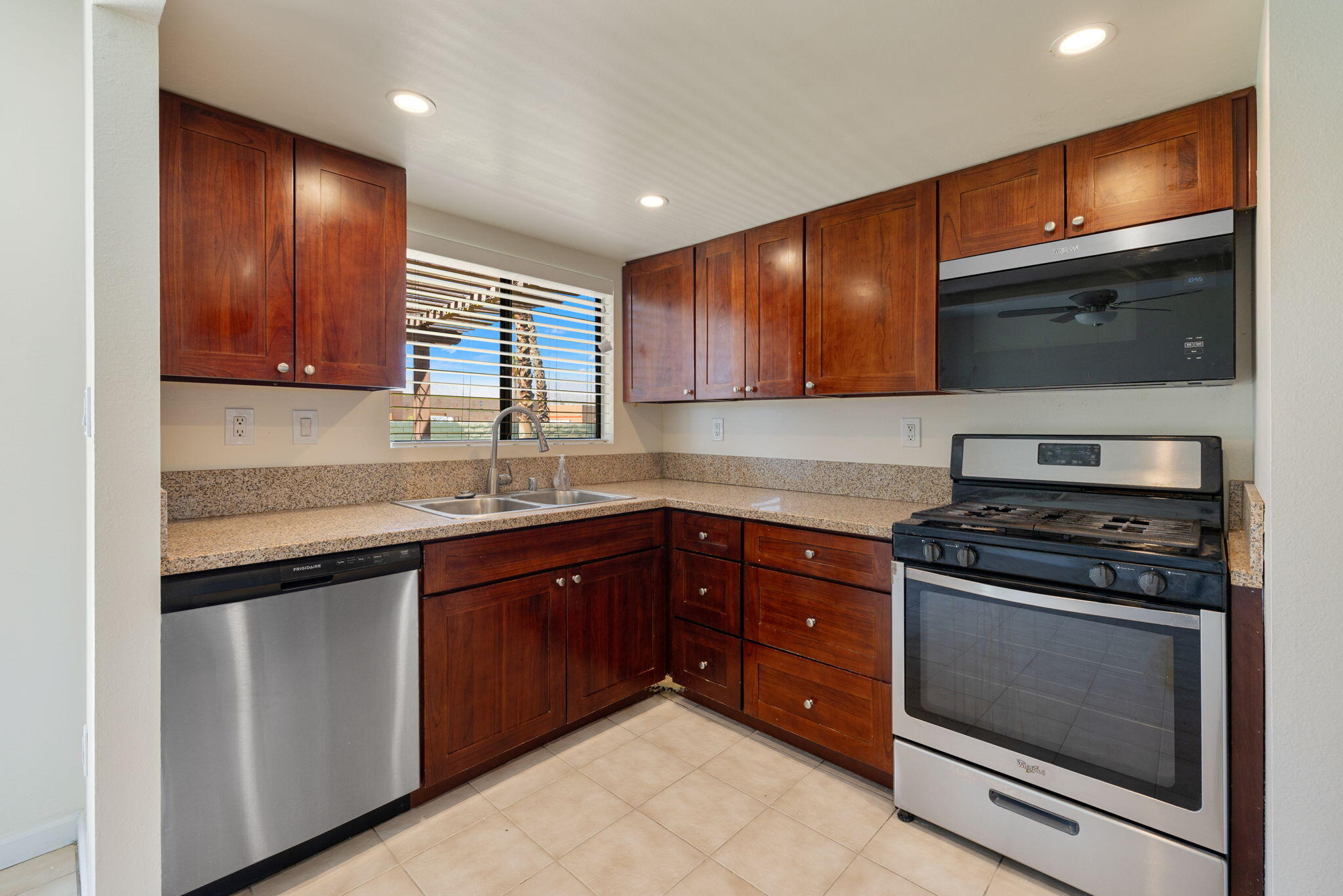 41885 Largo Palm Desert, CA 92211 - Photo 10 of 26 a kitchen with stainless steel appliances granite countertop wooden cabinets and a stove top oven