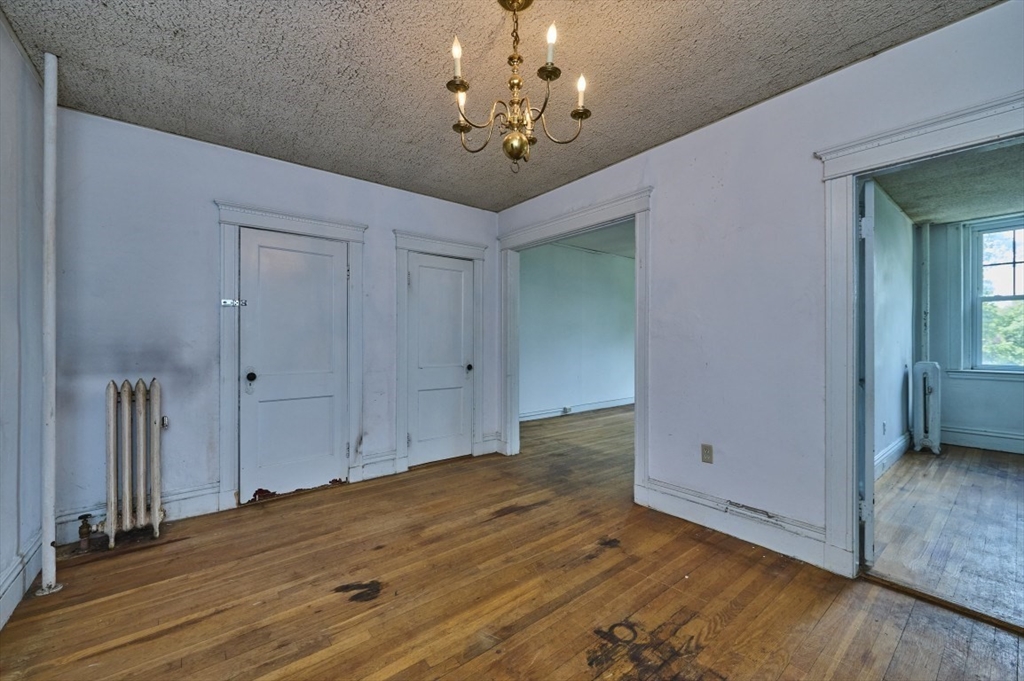 386 Riverway, Unit 4 Boston, MA 02115 - Photo 2 of 14 a view of a chandelier fan and wooden floor
