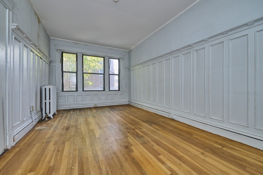 386 Riverway, Unit 4 Boston, MA 02115 - Photo 8 of 14 a view of an empty room with wooden floor and a window