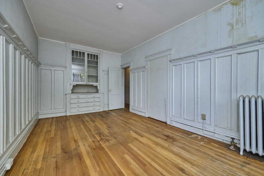 386 Riverway, Unit 4 Boston, MA 02115 - Photo 9 of 14 a view of an empty room with wooden floor and a window