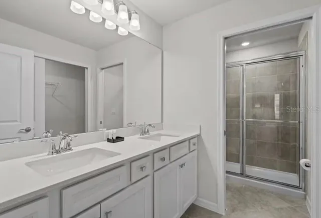 a bathroom with double sink and a mirror