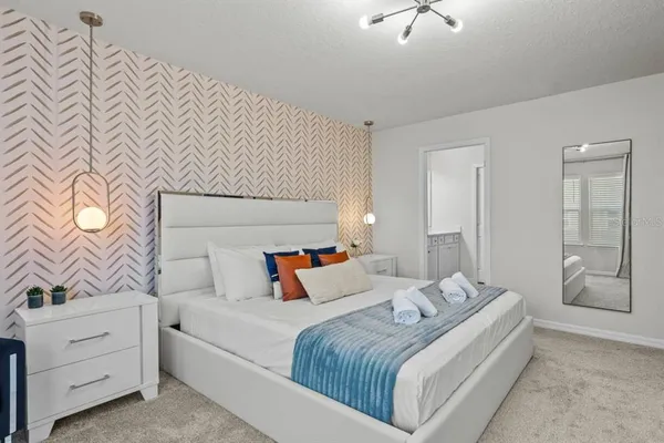 a bedroom with a bed and a chandelier