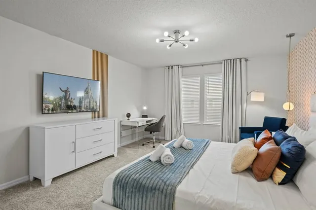 a bedroom with a bed and a chandelier