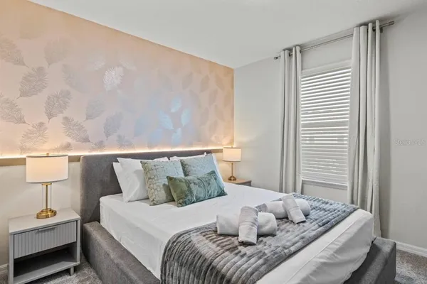 a bedroom with a bed and a painting on the wall