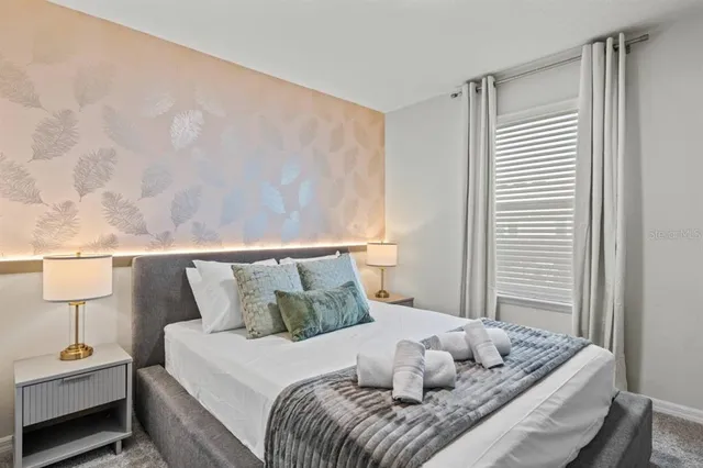 a bedroom with a bed and a painting on the wall