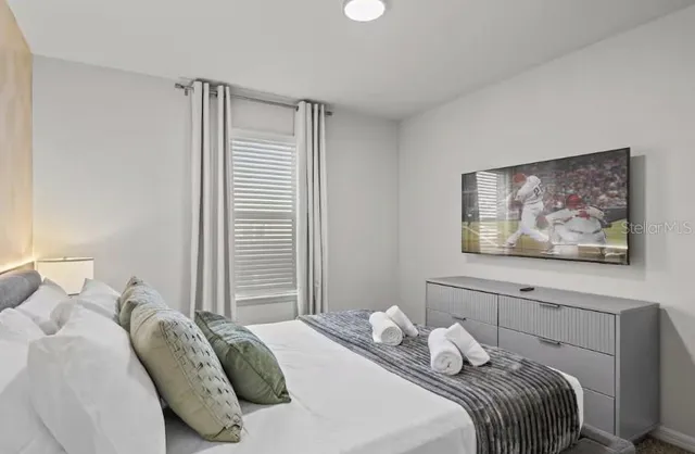 a bedroom with a bed and a flat screen tv