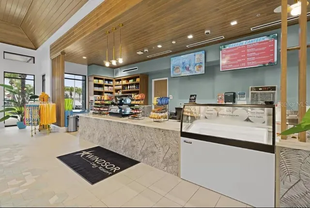 a kitchen with stainless steel appliances kitchen island granite countertop a dining table chairs and white cabinets