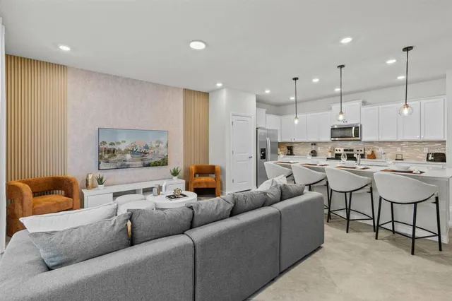 a living room with furniture kitchen and a chandelier