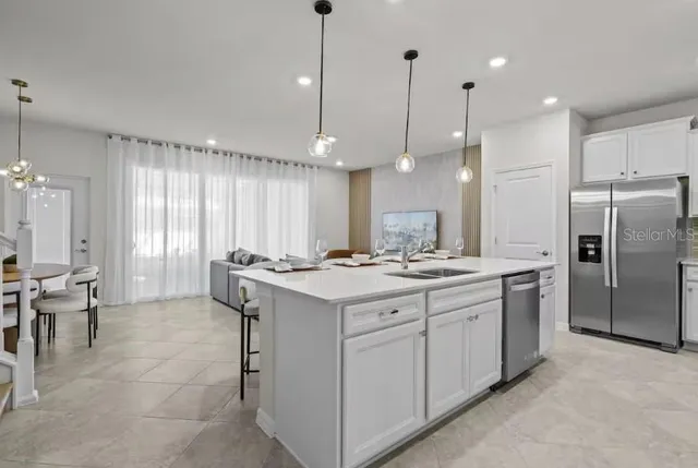 a kitchen with kitchen island a sink stove and refrigerator