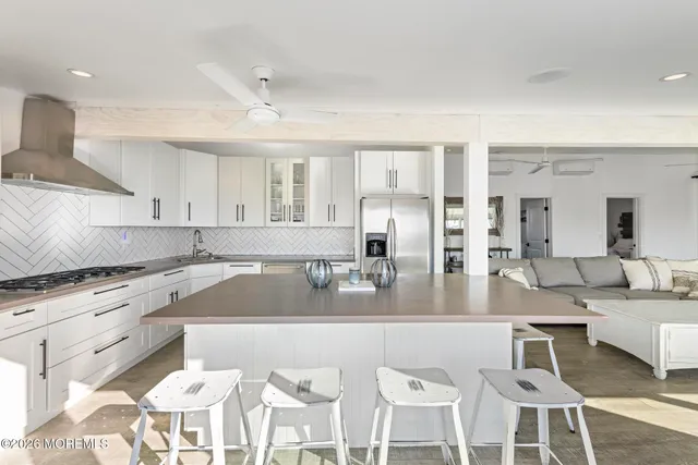a kitchen with stainless steel appliances granite countertop a sink and white cabinets