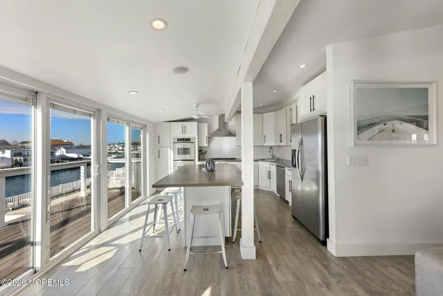 a kitchen with stainless steel appliances kitchen island granite countertop a refrigerator and cabinets