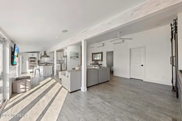 a view of a hallway with wooden floor and a kitchen