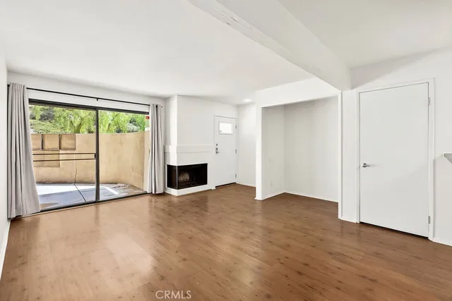 a view of a hallway with wooden floor and a kitchen