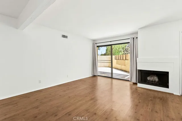 a view of a kitchen with wooden floor and a window