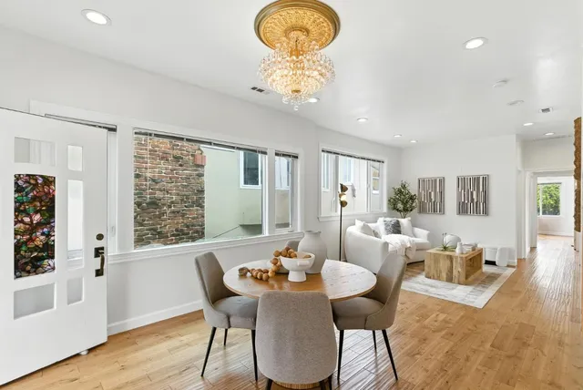 a kitchen with stainless steel appliances granite countertop a stove a sink dishwasher and white cabinets with wooden floor