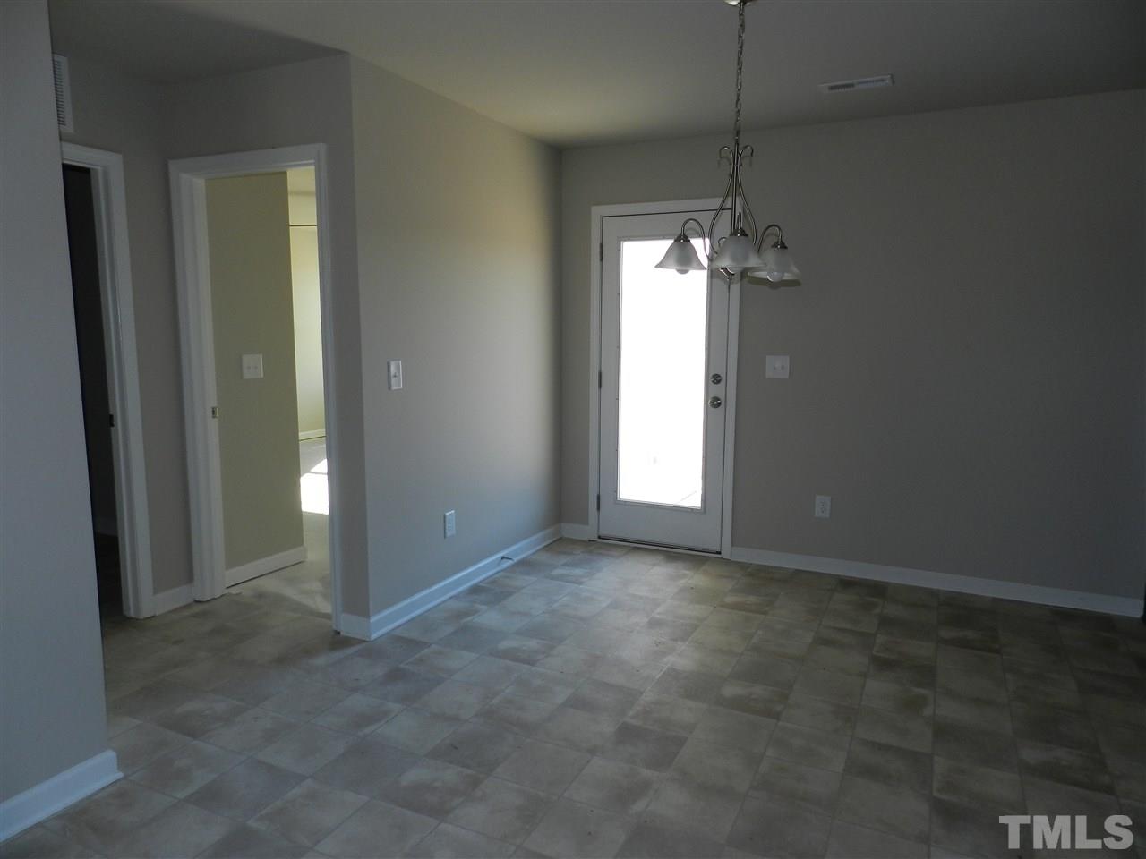 69 Willow Ridge Circle Willow Spring, NC 27592 - Photo 3 of 8 an empty room with chandelier fan and windows