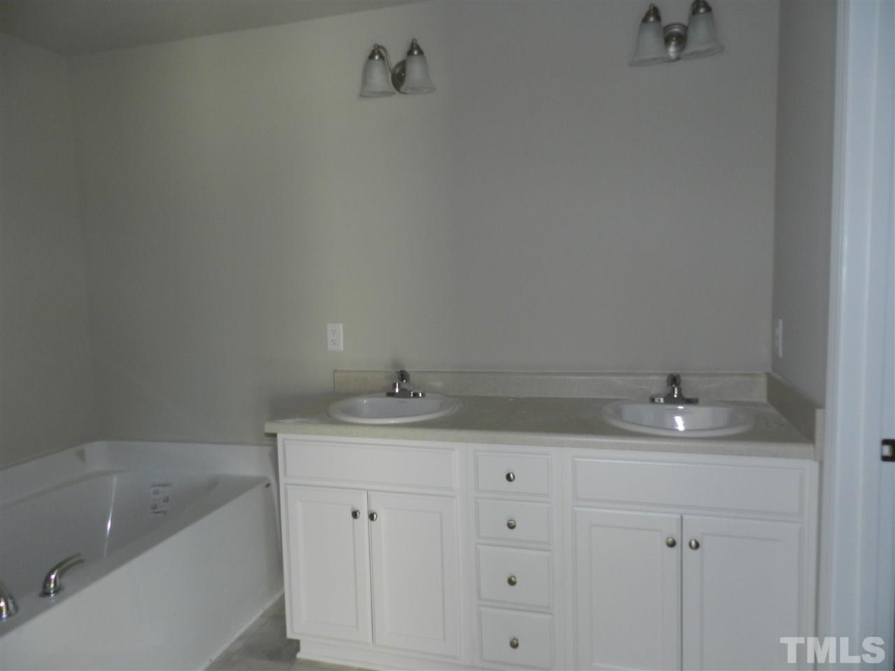 69 Willow Ridge Circle Willow Spring, NC 27592 - Photo 6 of 8 a bathroom with a granite countertop sink and white cabinets