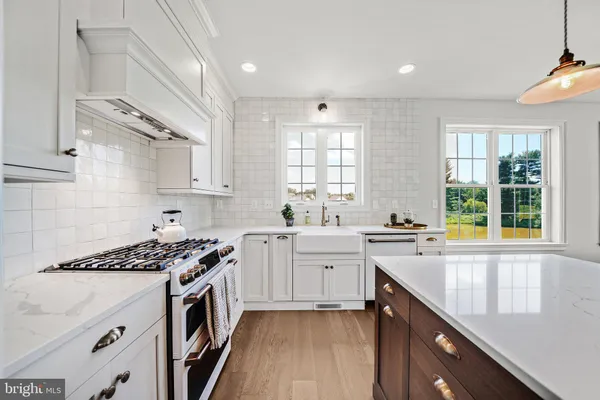 a kitchen with a stove a refrigerator a sink dishwasher with a dining table and chairs