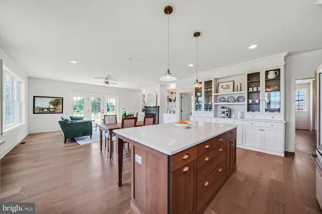 a large white kitchen with granite countertop a large window