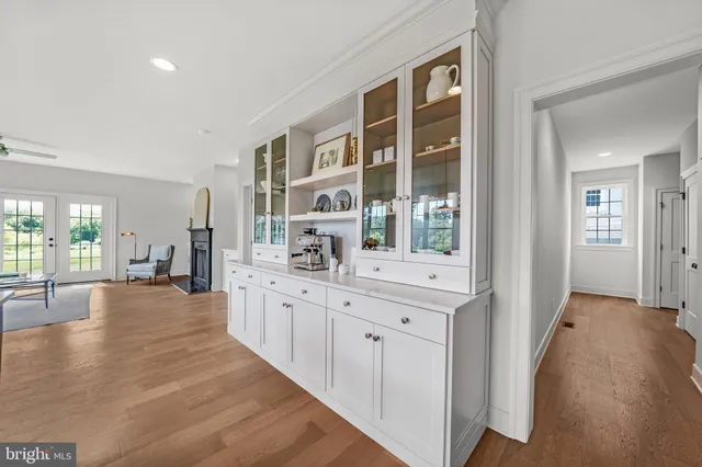 a kitchen with stainless steel appliances white cabinets and wooden floor