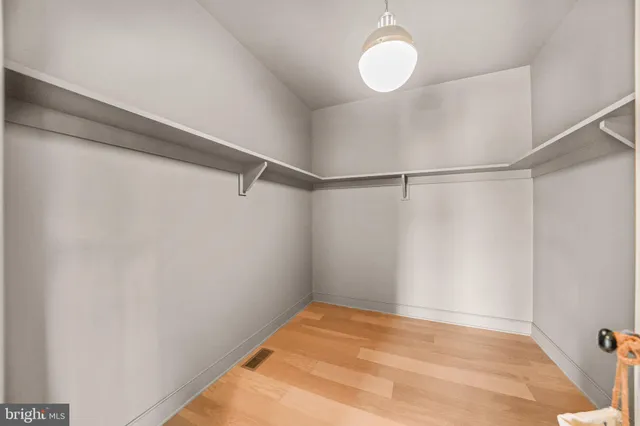 an empty room with windows and ceiling fan
