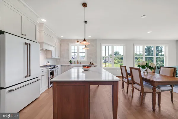 a large kitchen with granite countertop a sink a counter top space appliances and cabinets