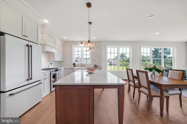 a large kitchen with granite countertop a sink a counter top space appliances and cabinets