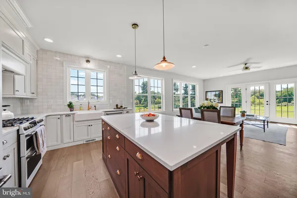 a large kitchen with stainless steel appliances granite countertop a sink a stove and a refrigerator