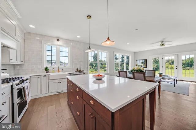 a large kitchen with stainless steel appliances granite countertop a sink a stove and a refrigerator