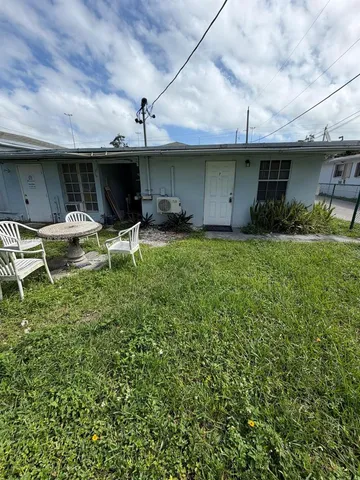 a backyard of a house with table and chairs